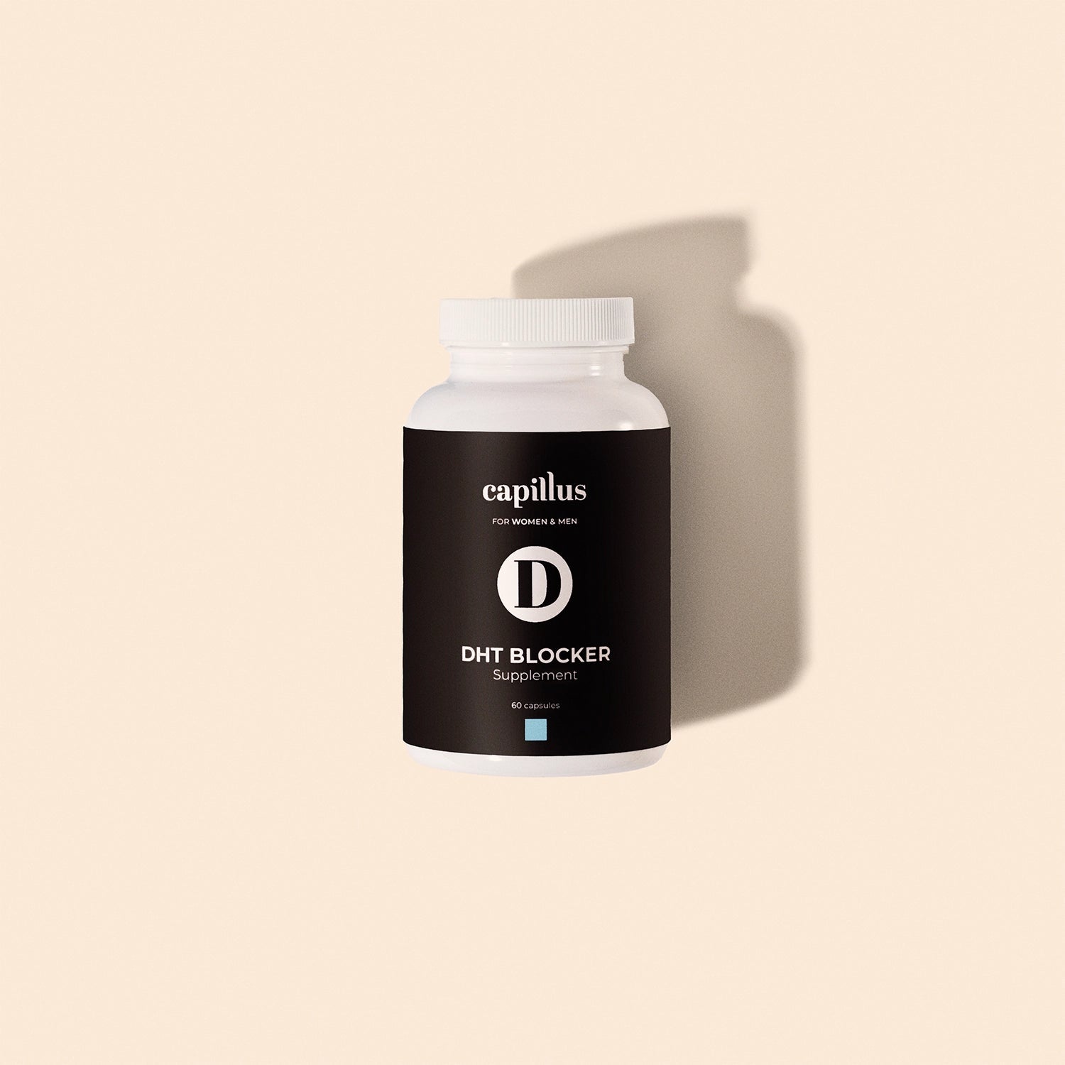 Un flacon blanc de Capillus DHT Blocker Tablet, de la marque Capillus, doté d'une étiquette noire et d'un bouchon blanc, est placé au centre d'un fond beige, avec une ombre légère sur la droite. Formulé pour aider à stimuler la pousse des cheveux chez les femmes et les hommes.