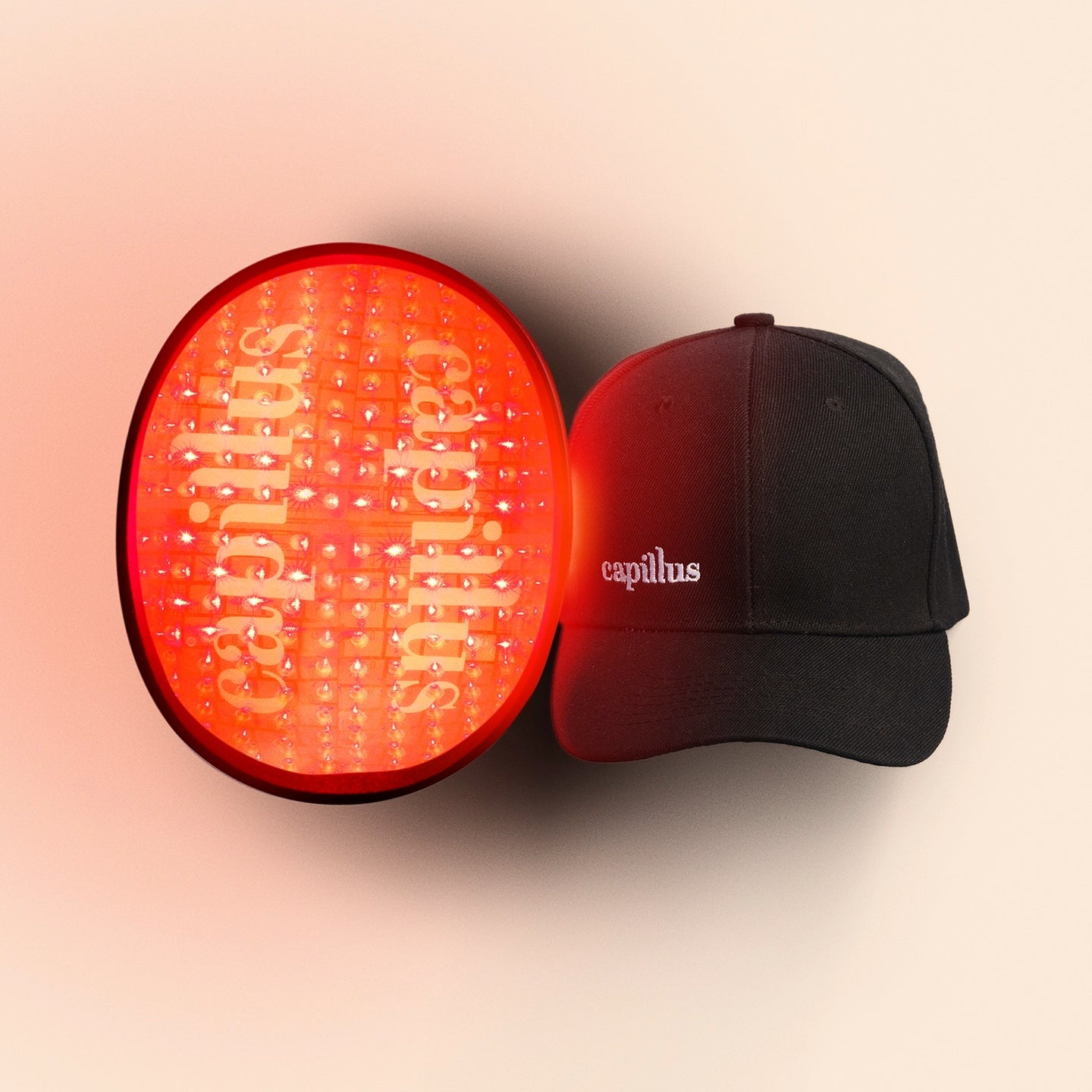 A black cap with Smart Cap branding sits next to the FDA-cleared Capillus TriSpectrum laser hair growth device, both labeled accordingly, against a light background.