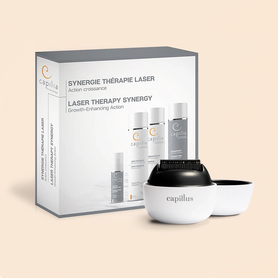 The Capillus Complete Growth Synergy Kit, including a derma roller, three bottles, and a comb device—all branded with the Capillus name—arrives in packaging featuring bilingual English and French text and is designed to provide advanced scalp treatment.